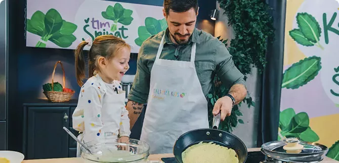 Kuvar uči malu djevojčicu da kuha